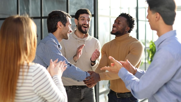 Zakenmannen schudden elkaar de hand in de gang van het auditorium