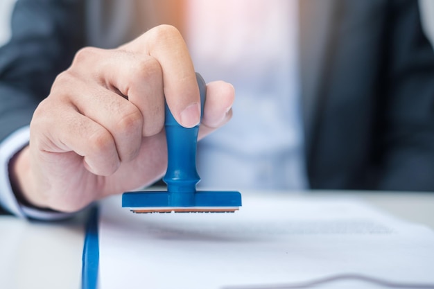 Zakenmanstempel tijdens ondertekening contractdocument Zakelijk contract keurt partnerschapscontractovereenkomst en kwaliteitsborgingsconcepten goed