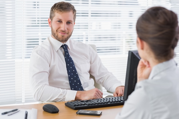 Zakenmanzitting met een medewerker aan zijn bureau