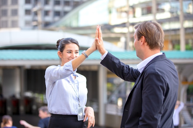 zakenmensen doen hi-five over prestatie tegen bouwen.