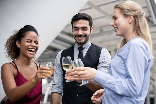 Zakenmensen klinken glazen en drinken wijn om het succesvolle werk te vieren. Groep bedrijfsmensen vieren door wijn met glimlach te drinken.