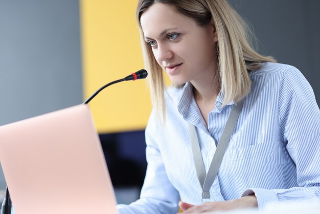 Zakenvrouw aanbrengen op laptop en sprekende microfoon