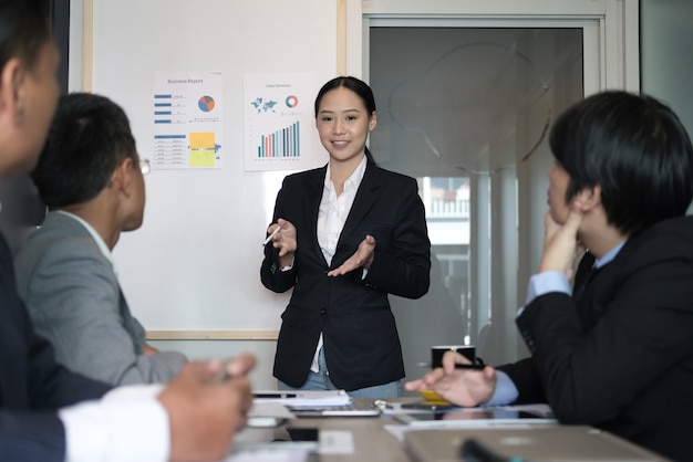 zakenvrouw aanwezig financieel plan rapport aan co-werker team. vrouwenleider bespreek gegevens