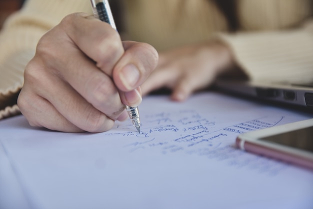 Zakenvrouw bedrijf pen en schrijven op papier