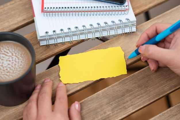 Zakenvrouw bedrijf pen en wijzend op belangrijk bericht op tafel met koffie en notebooks vrouw cruciale informatie op papier op bureau met koffie presenteren