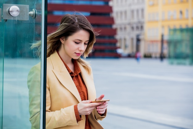 zakenvrouw bericht typen via de telefoon op het stadsplein