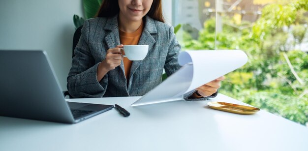 Zakenvrouw bezig met financieel papierwerk en laptopcomputer op kantoor