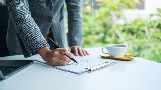 Zakenvrouw bezig met financieel papierwerk en laptopcomputer op kantoor