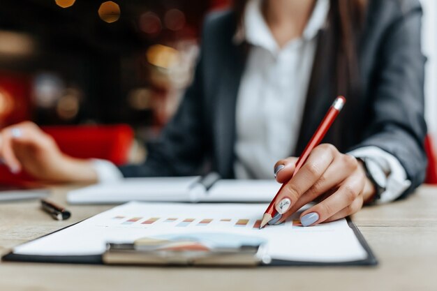 Zakenvrouw controleert grafieken en vernieuwt financiële vooruitgang. het meisje analyseert het bedrijfsmodel op de werkvloer.