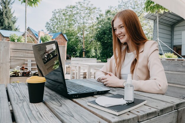 Zakenvrouw die buiten op de laptop werkt zakenvrouw die een videogesprek op afstand heeft terwijl