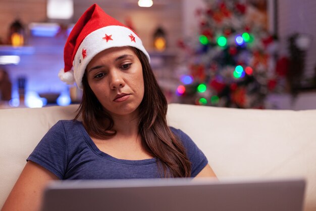 Zakenvrouw die de e-mail van het bedrijf leest op een laptopcomputer tijdens de kerst