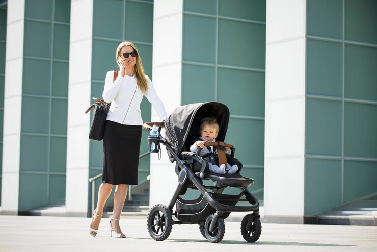 Foto zakenvrouw die een kinderwagen duwt en aan de telefoon praat
