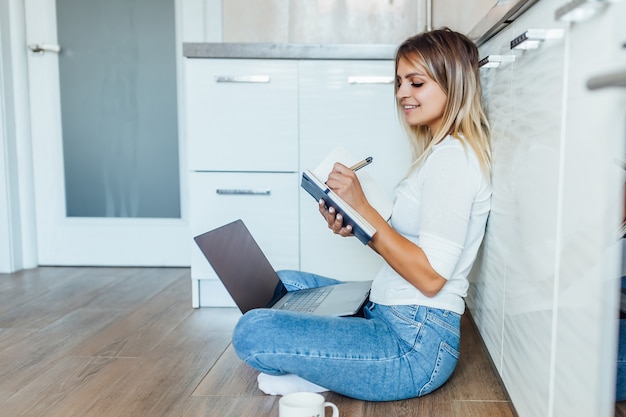 Zakenvrouw die een kopje koffie drinkt en haar laptop gebruikt om op een heldere ochtend te werken. thuiswerkconcept.