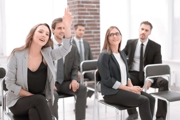 Zakenvrouw die hand opsteekt tijdens seminar