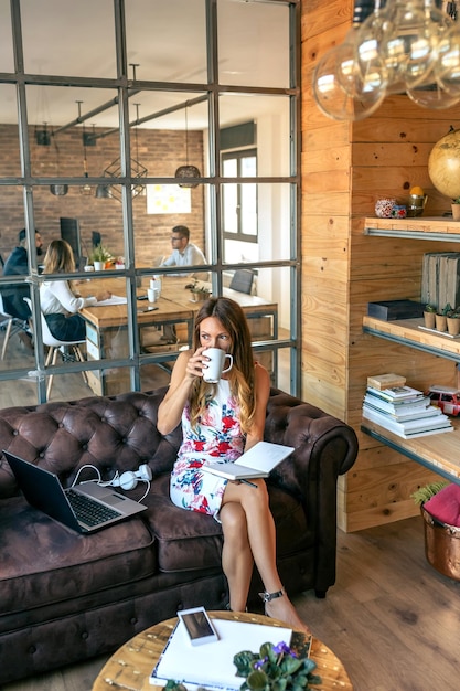 Zakenvrouw die koffie drinkt en werkt in een coworking-kantoor