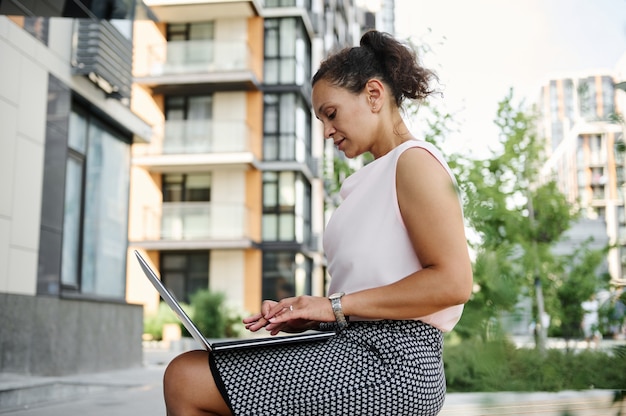 Zakenvrouw die op laptop buiten werkt. Zakelijk, werken op afstand en start-up concept