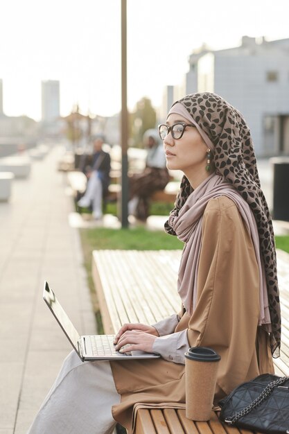 Zakenvrouw die op laptop buitenshuis werkt