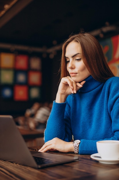 Zakenvrouw die op laptop in een café werkt