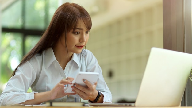 Zakenvrouw die op laptop kijkt terwijl ze de financiële winst op kantoor berekent