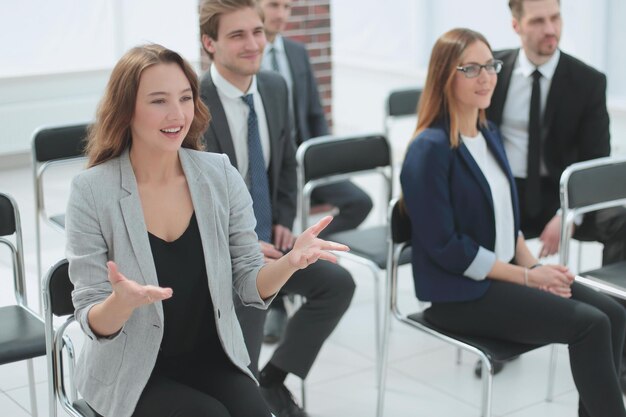 Zakenvrouw die vraag stelt tijdens de presentatie van haar collega's