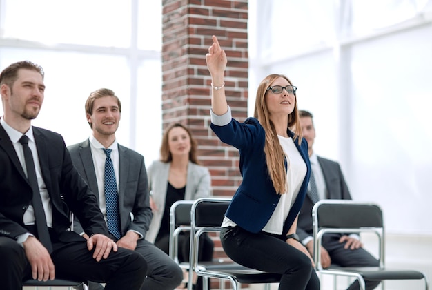 Zakenvrouw die vragen stelt tijdens seminar