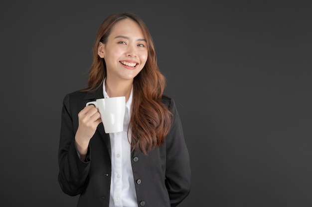 Zakenvrouw draagt een zwart pak Staande met een kopje koffie