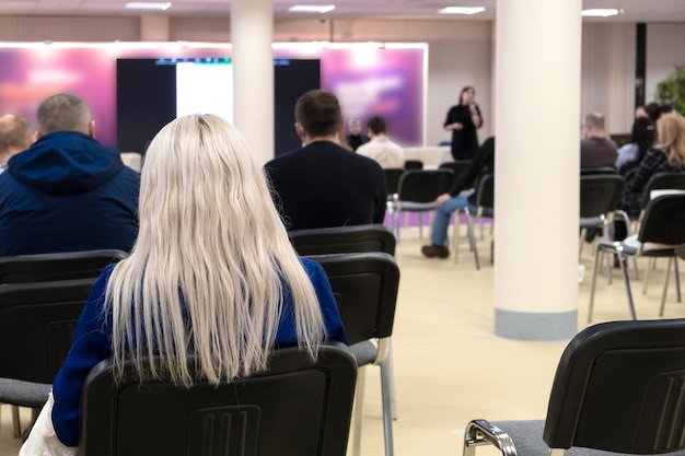 Zakenvrouw en mensen luisteren op de conferentie. Horizontale afbeelding