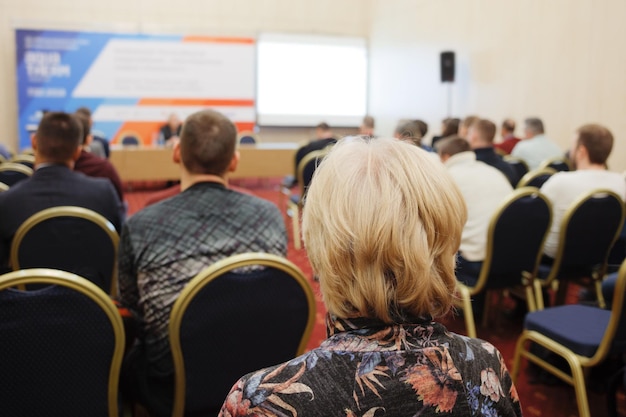 Zakenvrouw en mensen luisteren op het horizontale beeld van de conferentie