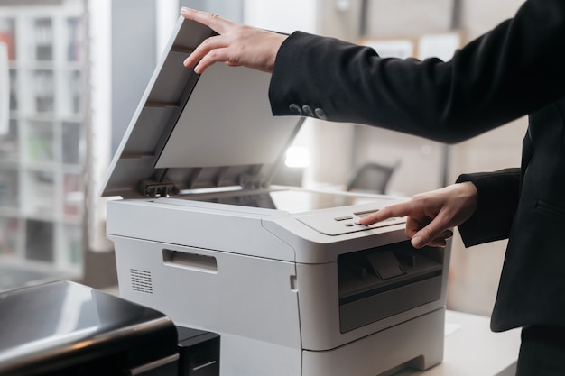 Foto zakenvrouw gebruikt de printer voor het scannen en afdrukken van documenten