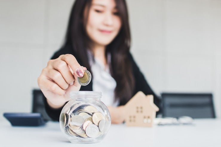 zakenvrouw geld te besparen in een glazen pot om thuis te komen, woning lening