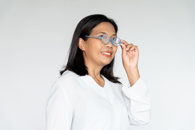 Foto zakenvrouw grijpt haar bril met oprechte glimlach op witte achtergrond