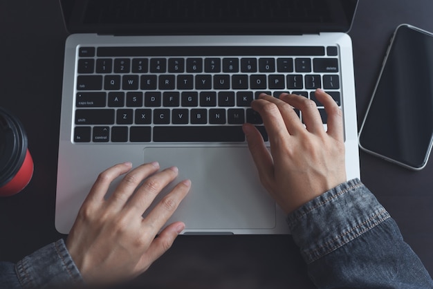 zakenvrouw hand typen op laptopcomputer op houten tafelblad weergave