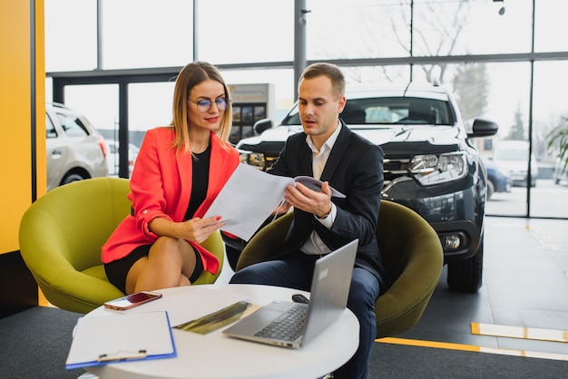 Zakenvrouw koopt een auto bij een autodealer.