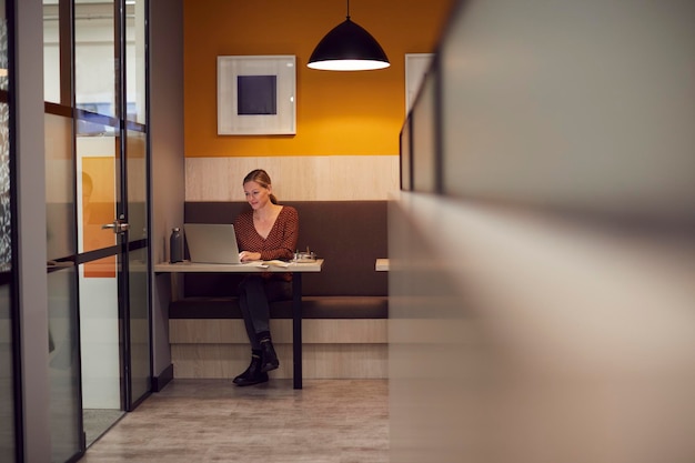 Zakenvrouw laat aan het werk in een open kantoor met behulp van laptop