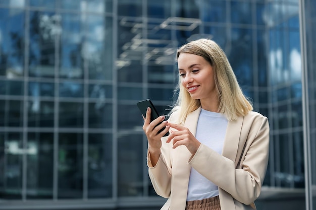 Zakenvrouw. Langharige blonde vrouw met een telefoon in de hand