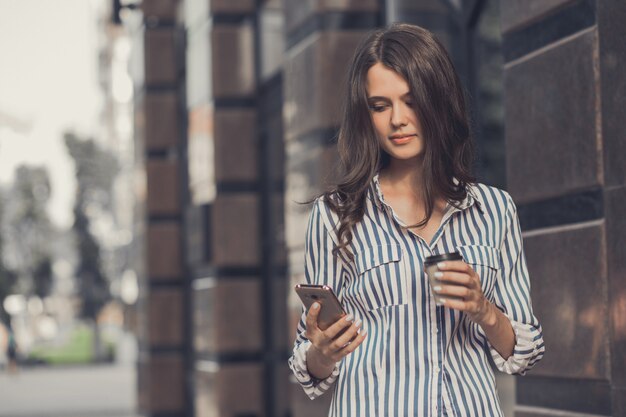 Zakenvrouw maakt gebruik van een mobiele telefoon, wandelen.