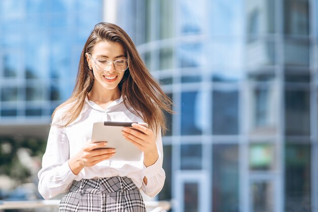 Zakenvrouw met behulp van tablet in de buurt van modern business center.