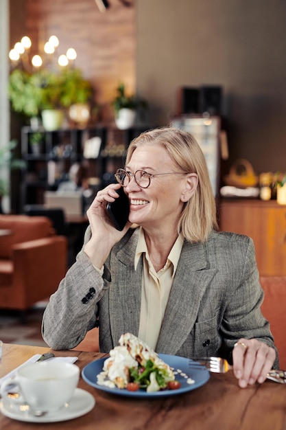 Zakenvrouw met behulp van telefoon tijdens de lunch