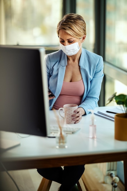 Zakenvrouw met een medisch beschermend masker werkt vanuit huis op de computer tijdens zelfisolatie en quarantaine om infectie tijdens griepvirusuitbraak en coronavirusepidemie te voorkomen.