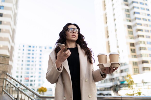 Zakenvrouw met kopjes koffie gaat aan het werk