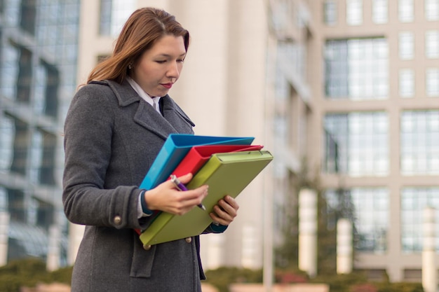 Zakenvrouw met mappen met documenten buitenshuis