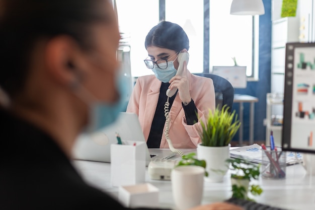 Zakenvrouw met medisch beschermend gezichtsmasker tegen coronavirus