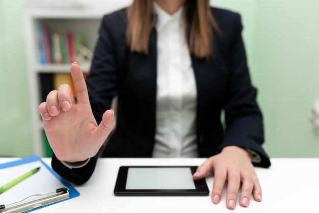 Zakenvrouw met Tablet op Bureau en wijzende belangrijke ideeën met één vinger Vrouw met telefoon weergegeven: recente updates Executive laat nieuws weergeven