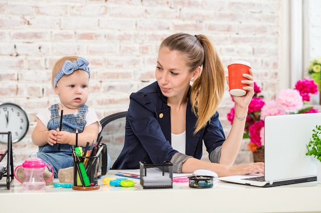 Zakenvrouw moeder vrouw met een dochter die bij de laptop werkt