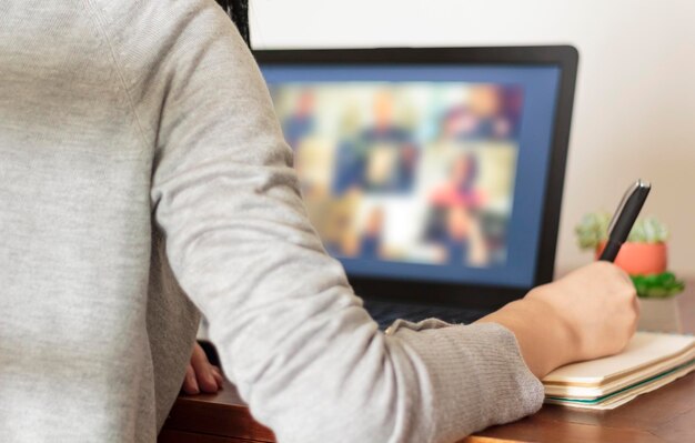 Foto zakenvrouw neemt aantekeningen bij een videoconferentie, vergadering, werk vanuit huis