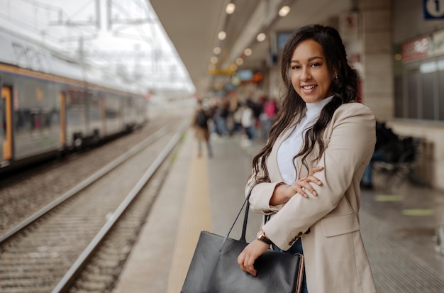 Zakenvrouw permanent op treinstation, kopieer ruimte. Vervoer, zakenreisconcept