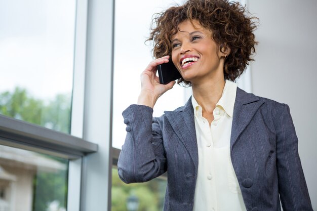 Zakenvrouw praten op mobiele telefoon op conferentiecentrum