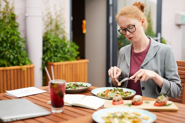 Zakenvrouw salade eten in café