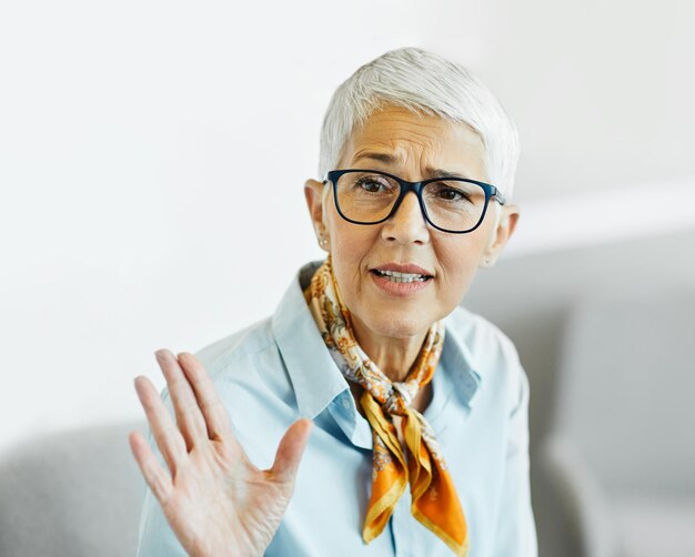 zakenvrouw senior ouderen kantoor bijeenkomst vrouw portret corporate manager glimlachend praten gesprek geluk volwassen bril communicatie discussie executive