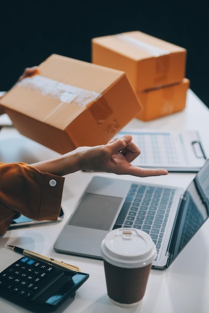 Foto zakenvrouw start een klein bedrijf en succesvolle kmo-ondernemers aziatische vrouw hoding boxs werkt thuis en levert pakketten online kmo-leveringconcept en verpakking